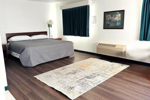 a bedroom with a bed and a rug at Bilmar Inn & Suites Dell Rapids Near Sioux Falls in Dell Rapids