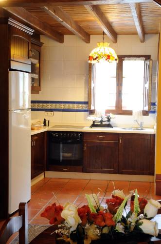 uma cozinha com uma mesa com flores em Casa Guela em Pajares