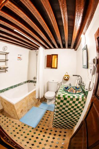 a bathroom with a tub and a toilet and a bath tub at Riad Nassim Fez in Fez