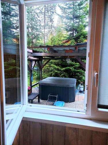 a window with a view of a table in a yard at Chata pod zubačkou in Tatranska Strba
