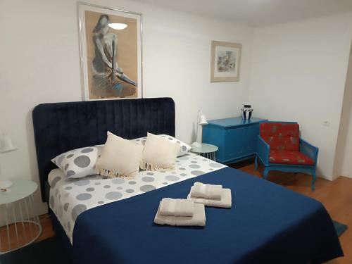 a bedroom with a blue bed with towels on it at Garden apartment Vanya in Split