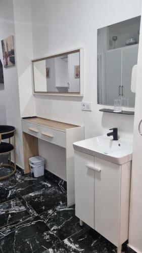 a white bathroom with a sink and a mirror at Pension Susita in Alicante