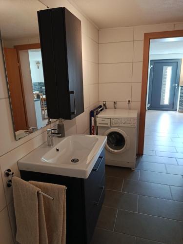 a bathroom with a sink and a washing machine at Gästehaus Michael in Navis