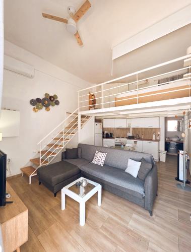 a living room with a couch and a staircase at Loft Suites - by Avelink in Spata