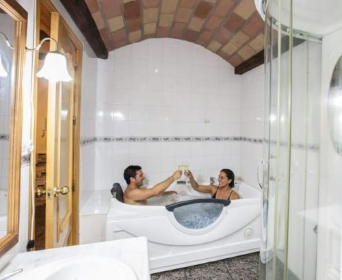 a man and a woman sitting in a bath tub at Alojamientos Rurales Benarum con Spa in Alpujarra de la Sierra