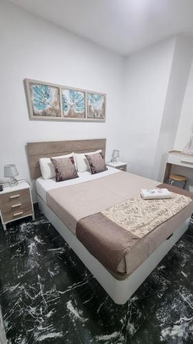 a bedroom with a bed and two paintings on the wall at Pension Susita in Alicante