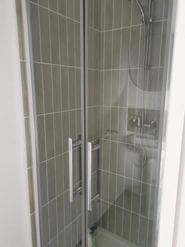 a bathroom with a shower with a glass door at Maison spacieuse - Perros Guirec in Perros-Guirec