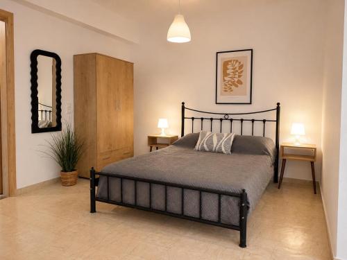 a bedroom with a bed and two tables and a mirror at Musses apartment 1 Modern Studio with Free Parking in Limín Khersonísou