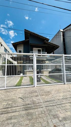 a white fence in front of a house at Pousada do Tio Cido in Guarujá