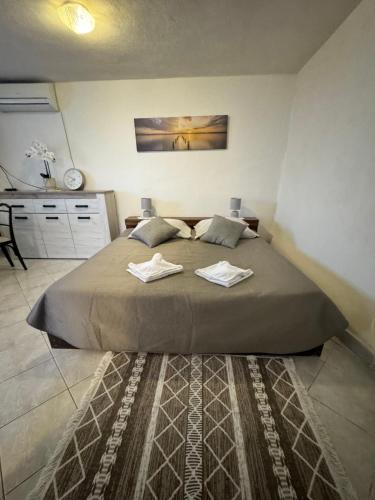 a bedroom with a large bed with two towels on it at Studio Apartment Rose in Selca