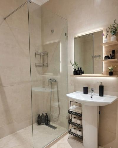 a white bathroom with a shower and a sink at Asilah Cozy Pieds dans l'eau in Asilah