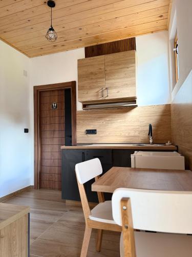 a kitchen with wooden ceilings and a wooden table and chairs at Tri ville in Žabljak