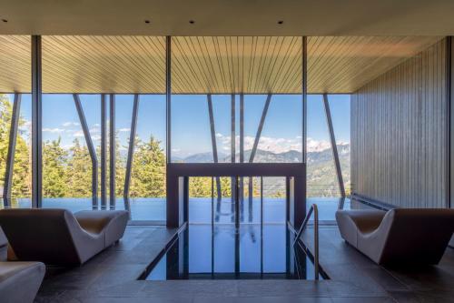 a living room with a view of the water and mountains at Hotel Olangerhof in Valdaora