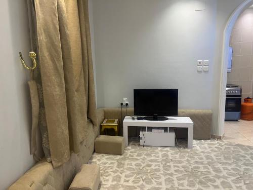 a living room with a television and a table at لافندر الطائف 2 in Taif