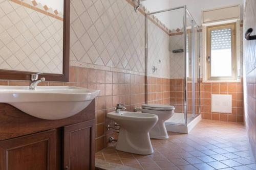 a bathroom with a sink and a toilet and a shower at Casa Vacanza Colletta - appartamenti e lido in Casteldaccia