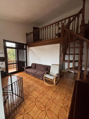 a living room with a couch and a staircase at Dimora Ludovica in Selvino