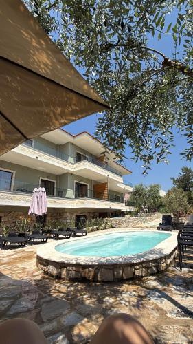 a swimming pool in front of a large building at Olea Apartments in Potos