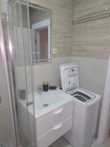 a bathroom with a sink and a washing machine at Sofija in Radanovići