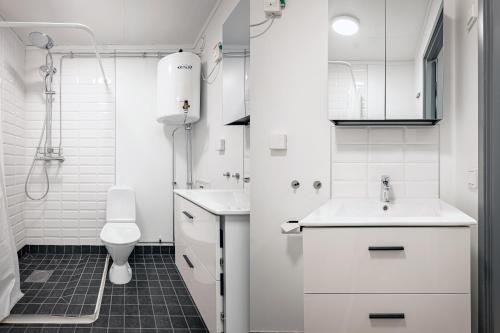 a white bathroom with a sink and a toilet at First Hotel Jönköping North in Jönköping