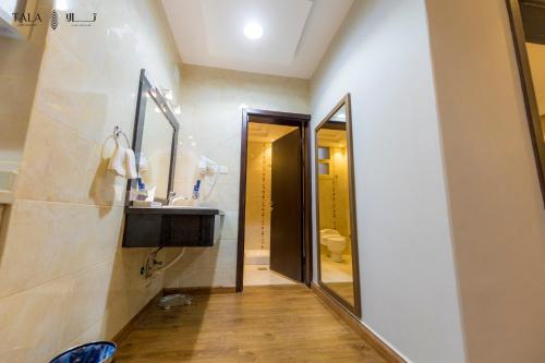 a bathroom with a sink and a mirror at شقق ركن تالا للشقق المفروشة - اقتصادي in Buraydah