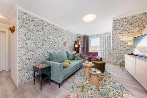 a living room with a blue couch and a tv at Ferienwohnung Morgen am Meer in Sassnitz