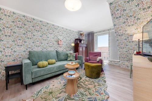 a living room with a green couch and a table at Ferienwohnung Morgen am Meer in Sassnitz
