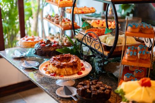 a table with a bunch of cakes and other desserts at Royal Turquesa Boutique Hotel in Búzios