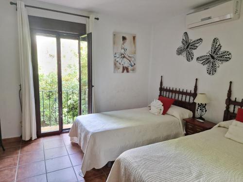 a bedroom with two beds and a balcony at Casa Jardin Alhambra in Granada