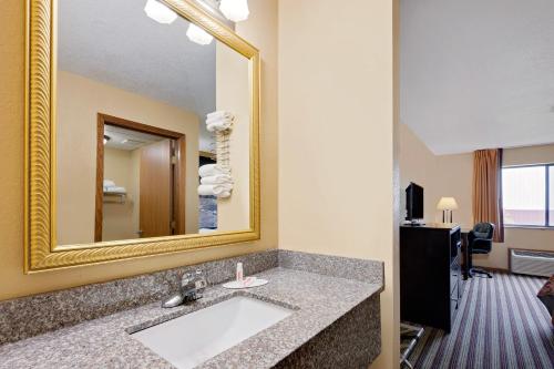 a bathroom with a sink and a mirror at Super 8 by Wyndham Iowa Falls in Iowa Falls