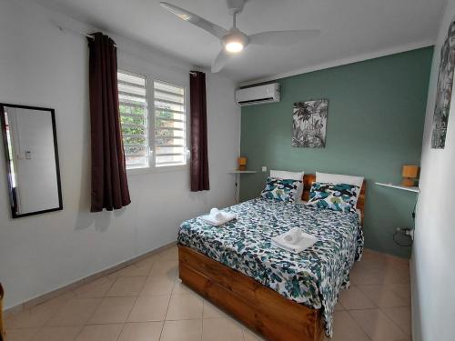 a bedroom with a bed in a room at LE MANGO COSY ZEN proche de l'aéroport in Les Abymes