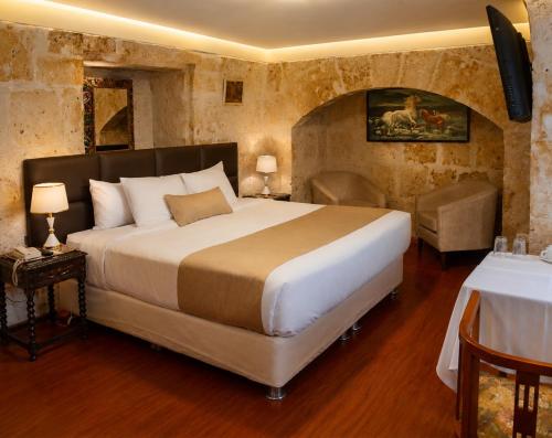 a bedroom with a large bed and a table at Hotel Santa Rosa in Arequipa