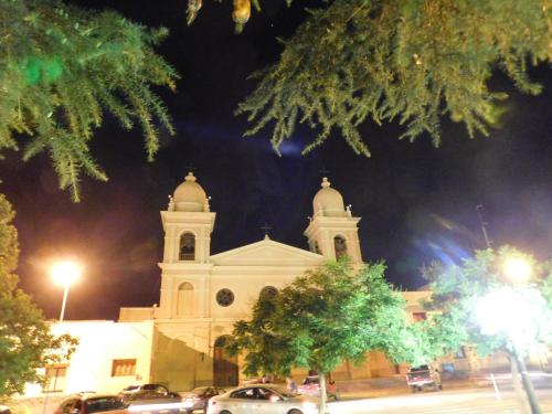 a church at night with cars parked in front of it at Hotel Portal del Santo in Cafayate