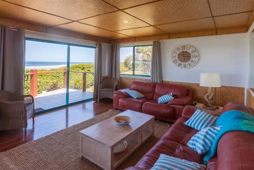 a living room with a couch and a table at White Waves on the Beach in Hastings Point