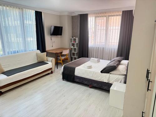 a bedroom with a bed and a couch and a table at Upart Flats by REFE in Antalya