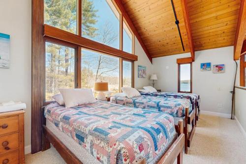 two beds in a room with large windows at Lake Shore Drive in Franklin