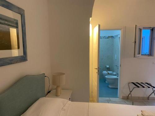 a bedroom with a bed and a bathroom with a toilet at Dallatorre B&B in Lizzano