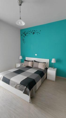 una camera da letto con un grande letto e una parete blu di Una Stanza In Centro a Gaeta