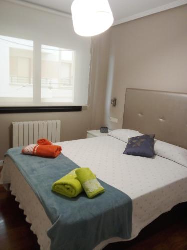 two towels sitting on a bed in a bedroom at Apartamento Ogoño in Mundaka