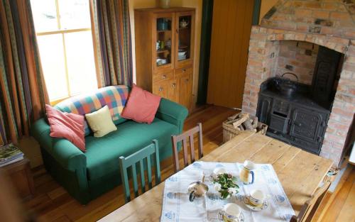 sala de estar con sofá y chimenea en Historic Shearers Quarters en Ruahine