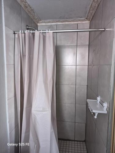a shower with a white shower curtain and a sink at Mams Cozy Guest house in Seshego