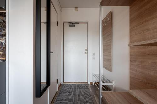 a hallway with a white door and a mirror at First Hotel Halmstad East in Halmstad