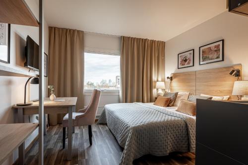a hotel room with a bed and a desk at First Hotel Halmstad East in Halmstad