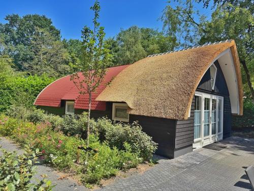 a small house with a thatched roof at Koning te Rijk - Residence de Eese in De Bult
