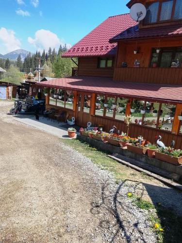 a building with flowers on the side of it at Садиба "У Валентини" in Yablunytsya