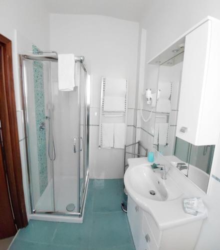 un bagno bianco con doccia e lavandino di Una Stanza In Centro a Gaeta