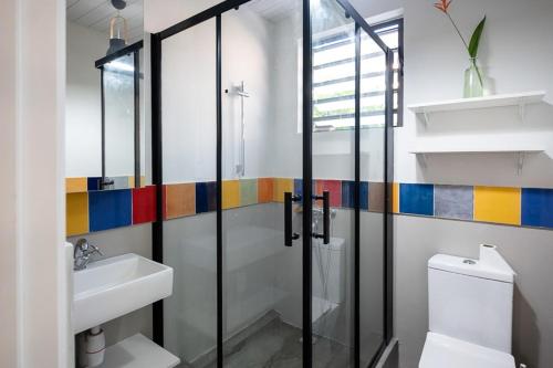 a bathroom with a shower and a toilet and a sink at Blue Zebra - Le Jardin d'Antoinette in Rivière Noire