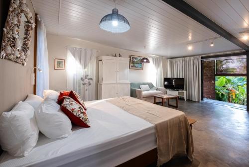 a bedroom with a large bed and a living room at Blue Zebra - Le Jardin d'Antoinette in Rivière Noire