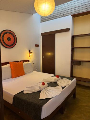 a bedroom with a bed with towels on it at Samba Pousada in Jericoacoara