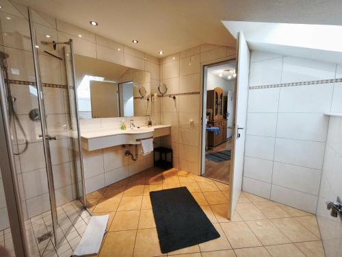 a bathroom with a shower and a sink and a mirror at fewolehr in Ulm