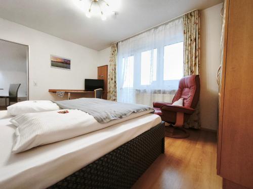 a bedroom with a bed and a chair and a window at fewolehr in Ulm